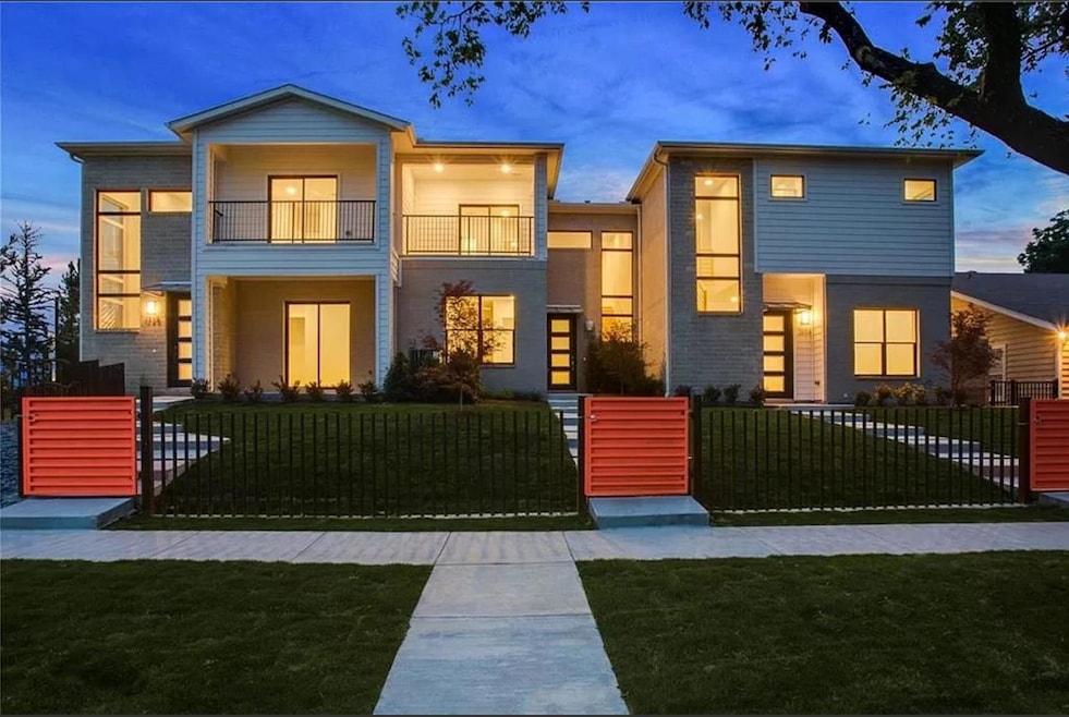Contemporary home featuring a balcony, a fenced fr