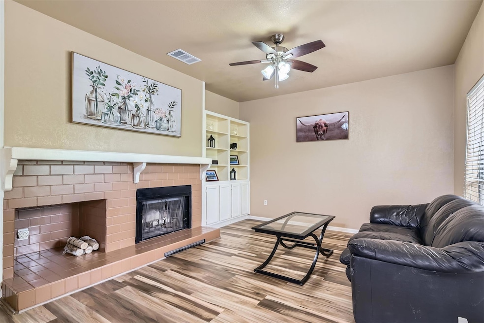 Living room featuring a brick fireplace, ceiling 
