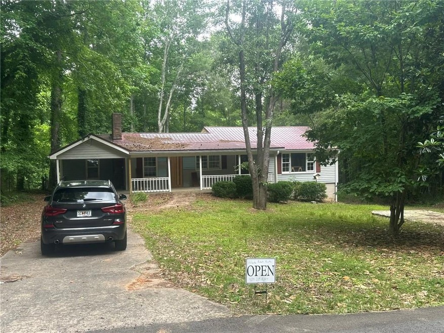 Ranch-style house featuring a porch and a carport