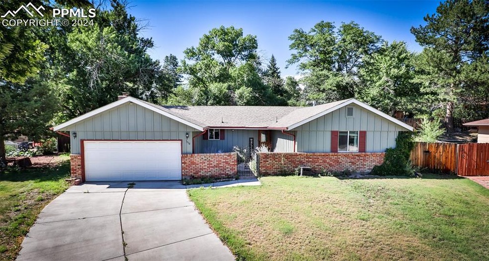 Ranch-style home featuring a garage and a front ya