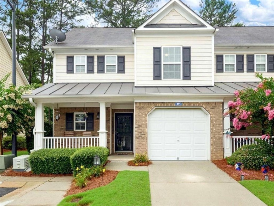 Craftsman-style house with brick siding, a porch, a standing seam roof, an attached garage, and concrete driveway