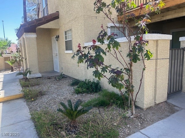 View of property exterior featuring fence and stuc