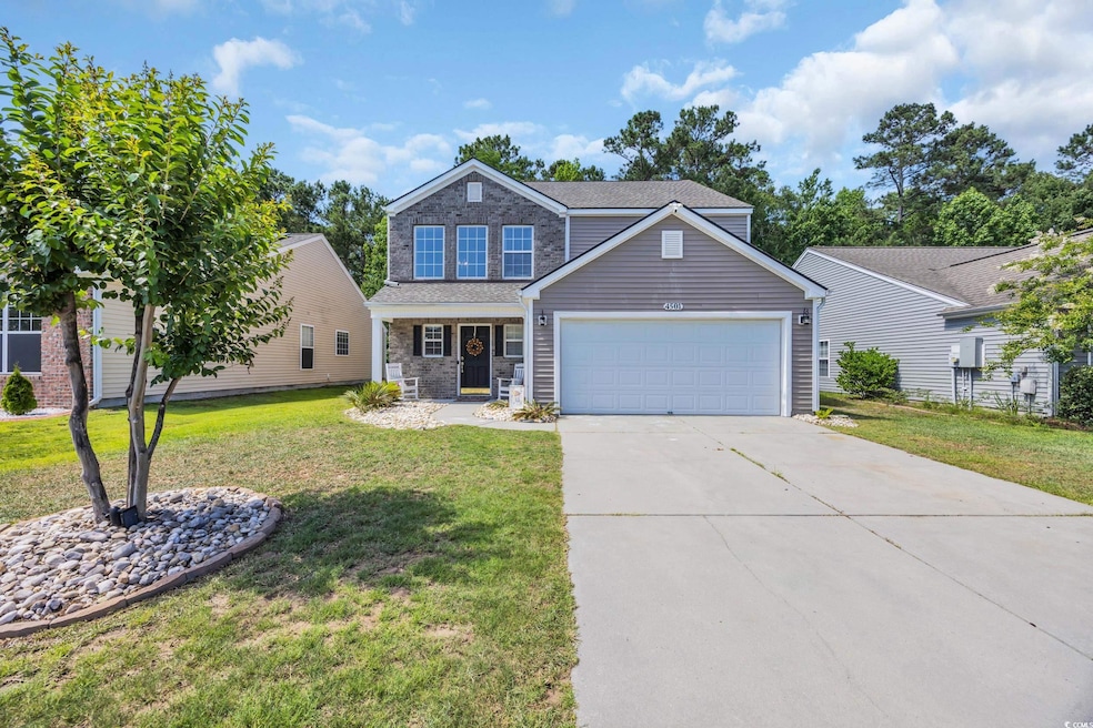 View of front of property with an attached garage, a front lawn, and concrete driveway