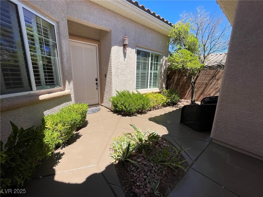 Entrance to property with stucco siding, a patio,