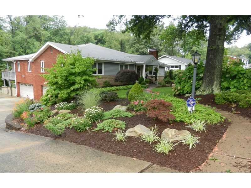 Exterior Front. Lush landscaping with flowers all 