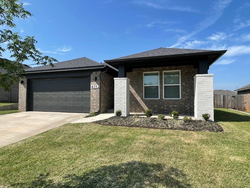 View of front of home featuring a garage, driveway, and brick siding