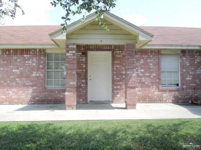 Ranch-style home featuring brick siding, a front yard, and concrete driveway