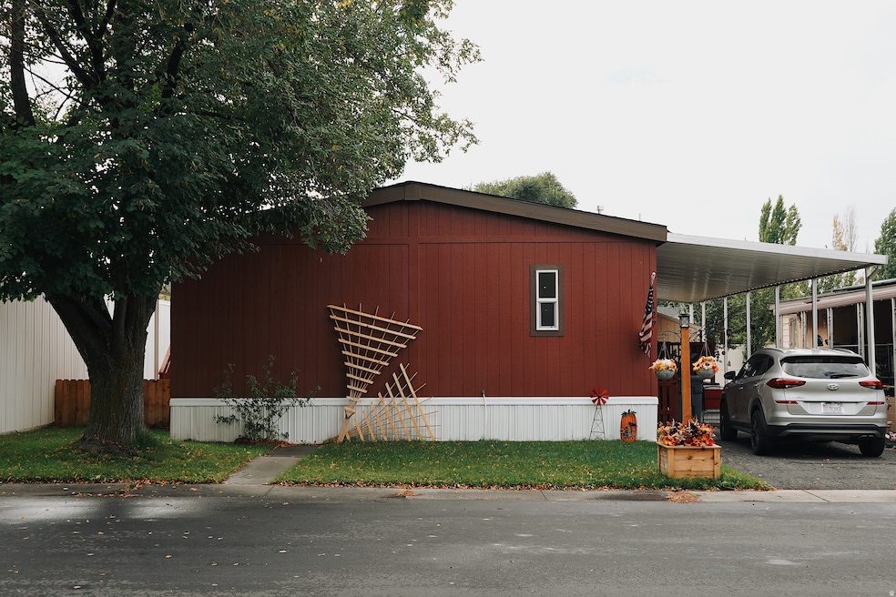 View of side of property featuring an attached carport and driveway