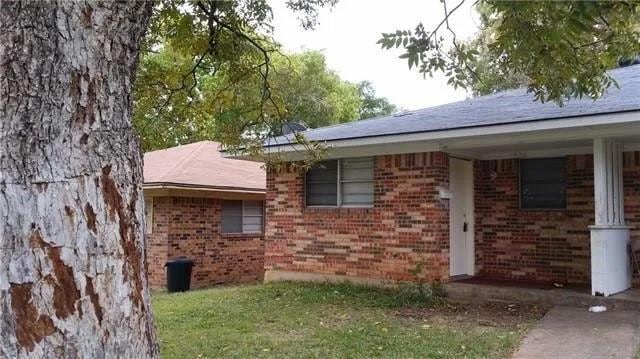 View of side of property featuring a lawn