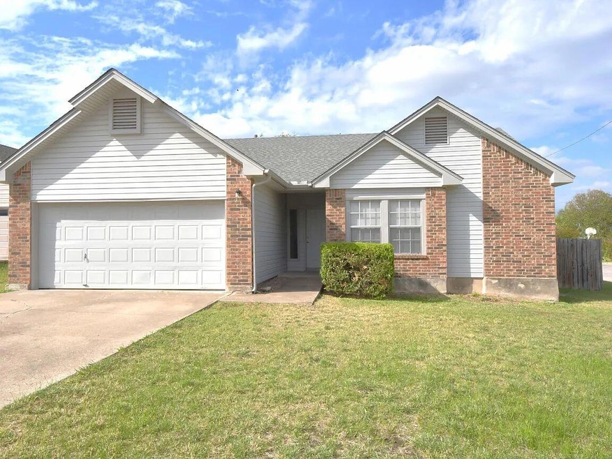 Ranch-style home featuring brick siding, a garage