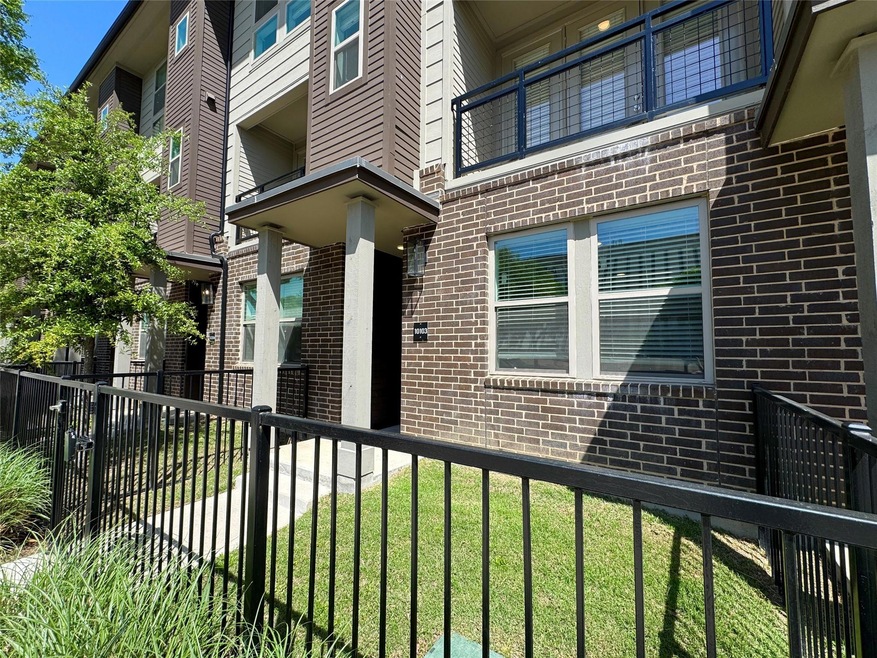 Property entrance featuring a yard, fence, and bri