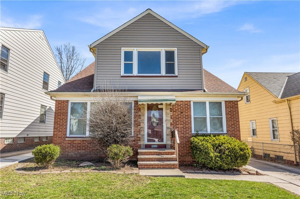 Traditional home featuring brick siding, a front lawn, and roof with shingles