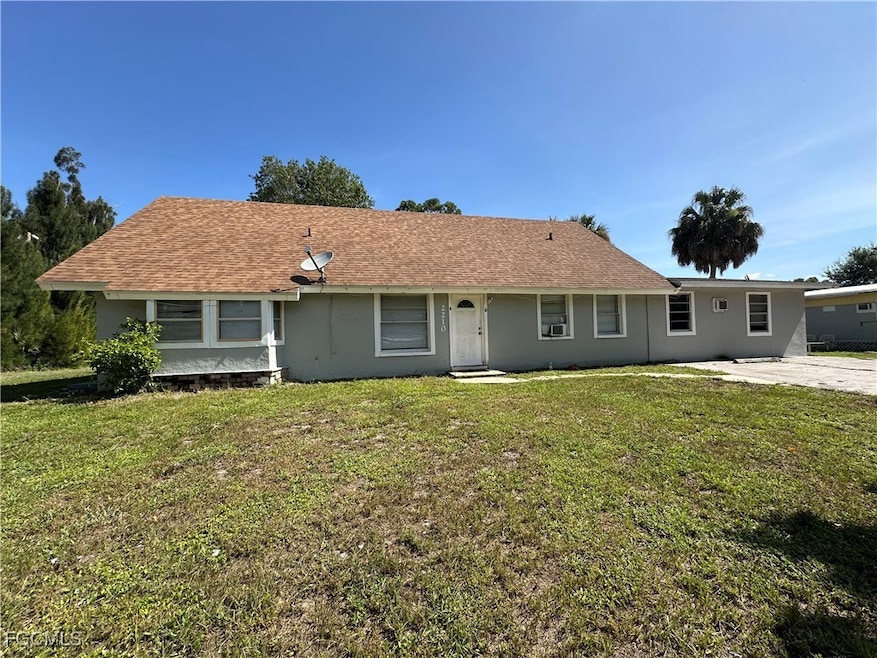 Ranch-style house with a front yard, stucco siding, and a shingled roof