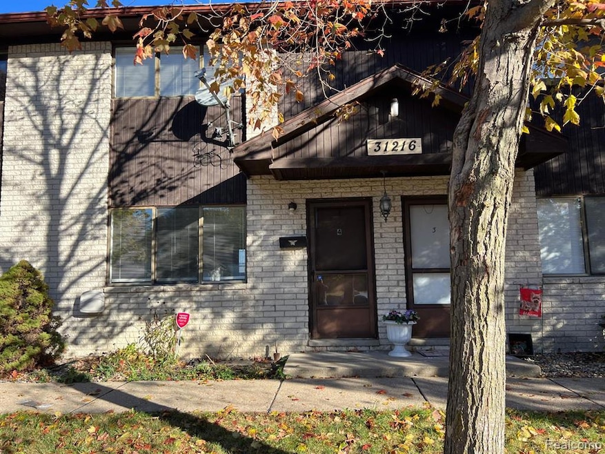 Doorway to property featuring brick siding