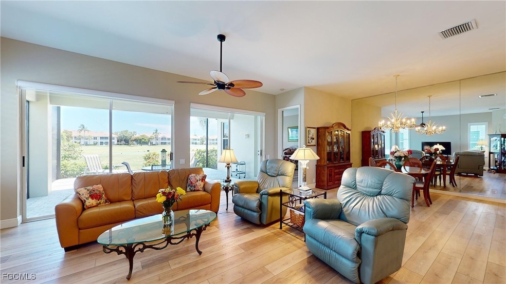 Living room featuring light wood-type flooring, a chandelier, and a ceiling fan