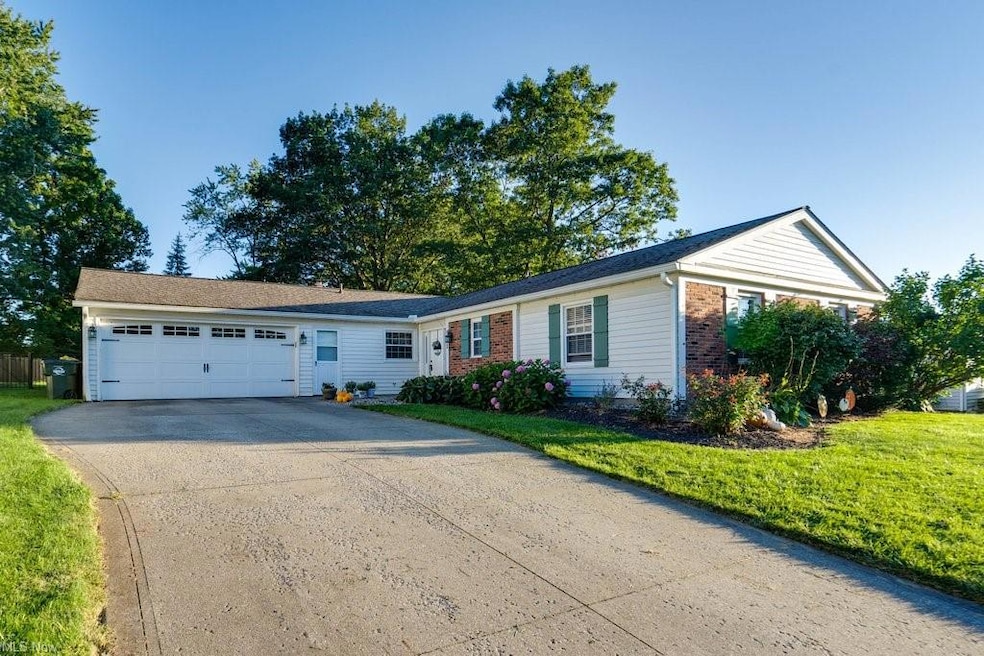 Ranch-style house featuring a front yard and garag