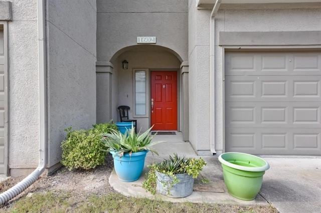 Doorway to property featuring stucco siding and a