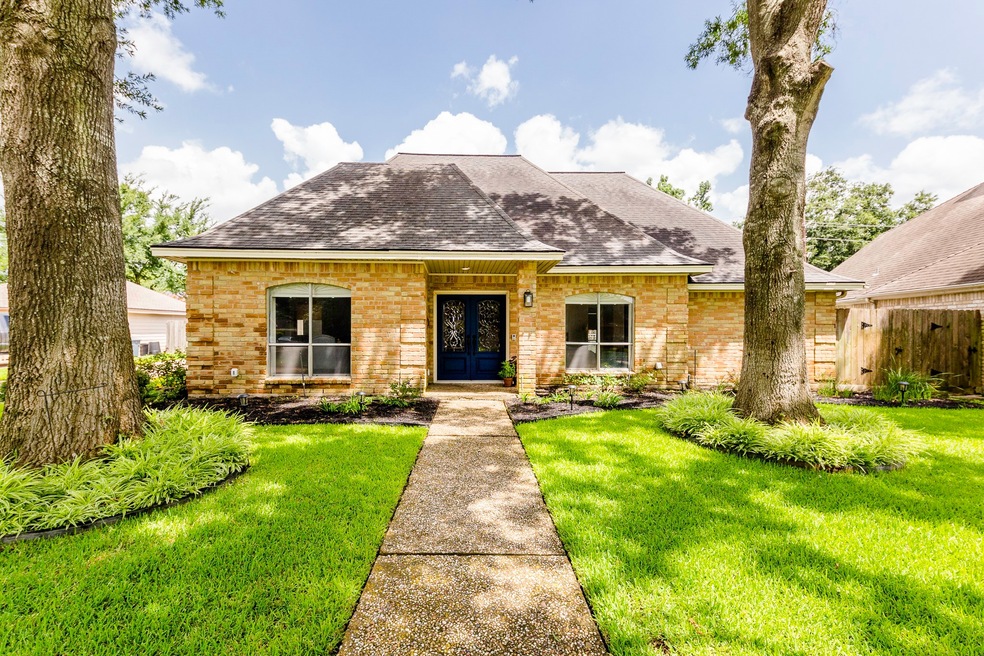Framed by two gorgeous oak trees in the front yard