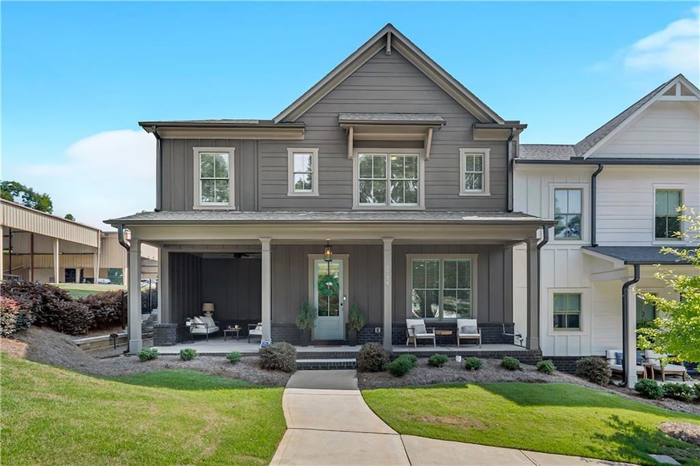 View of front of home featuring board and batten siding, covered porch, and a front yard