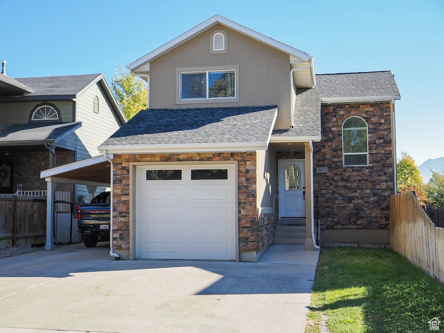 View of front of house featuring driveway, a shingled roof, and stone siding