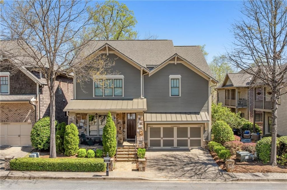 Craftsman-style home featuring stone siding, driveway, a standing seam roof, a porch, and a garage