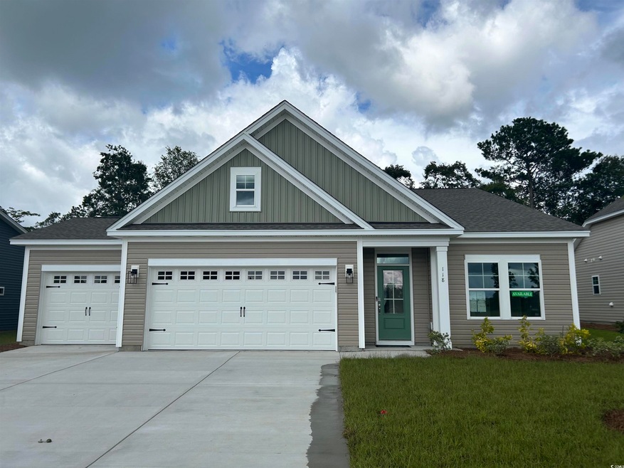 View of front of home with board and batten siding, driveway, a garage, and a front yard
