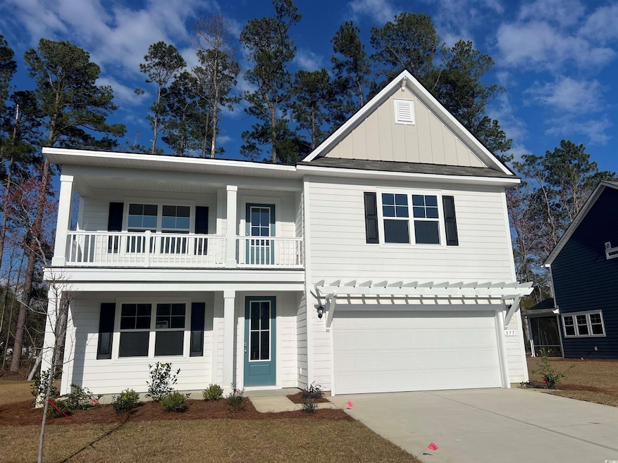View of front of property featuring a garage, a ba