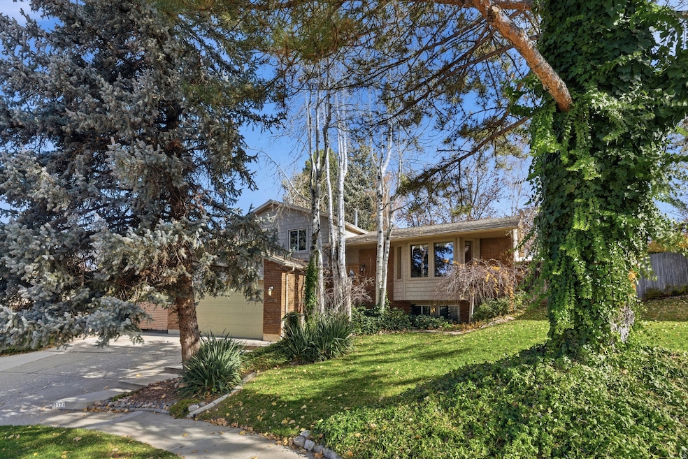 View of front of home featuring a front yard, concrete driveway, and brick siding