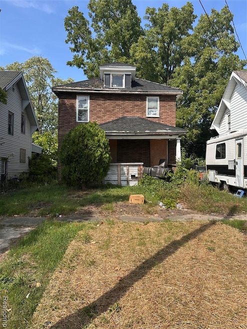 Traditional style home with brick siding and a front yard