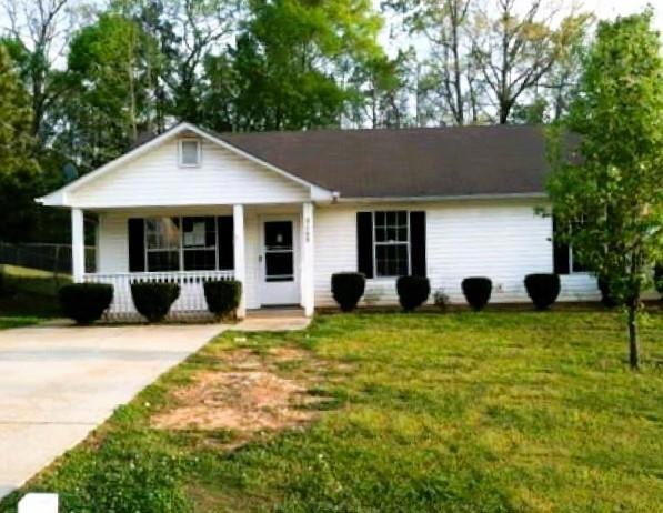 Ranch-style house featuring a front lawn and cover