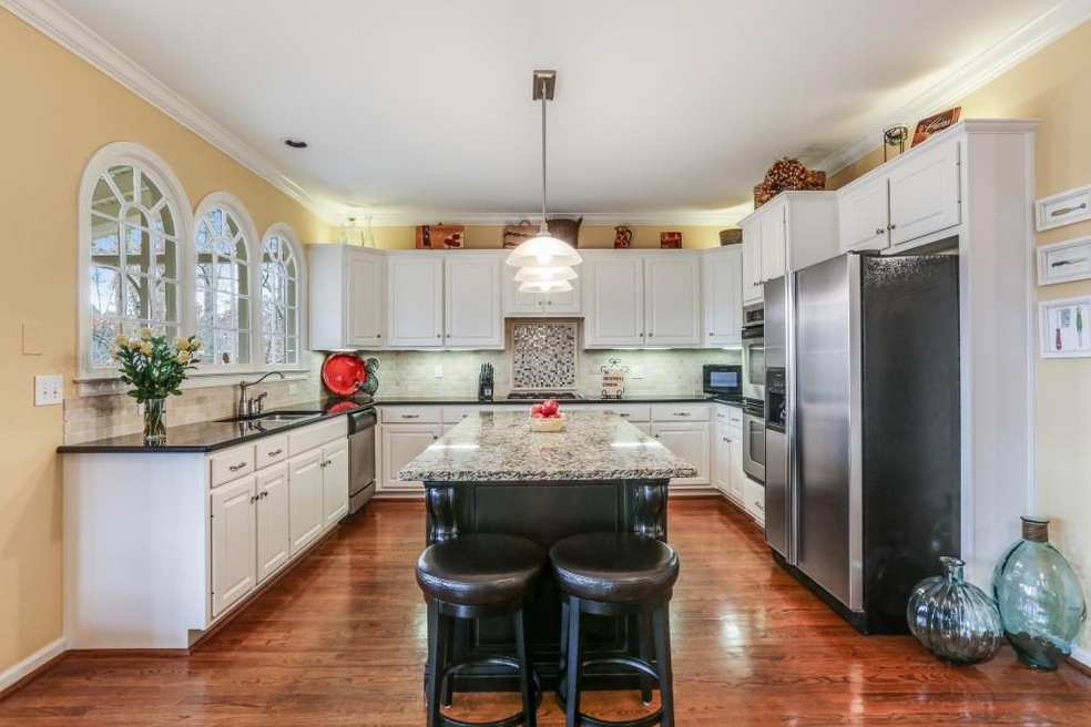 The updated kitchen features an oversized island, granite countertops and stainless steel appliances