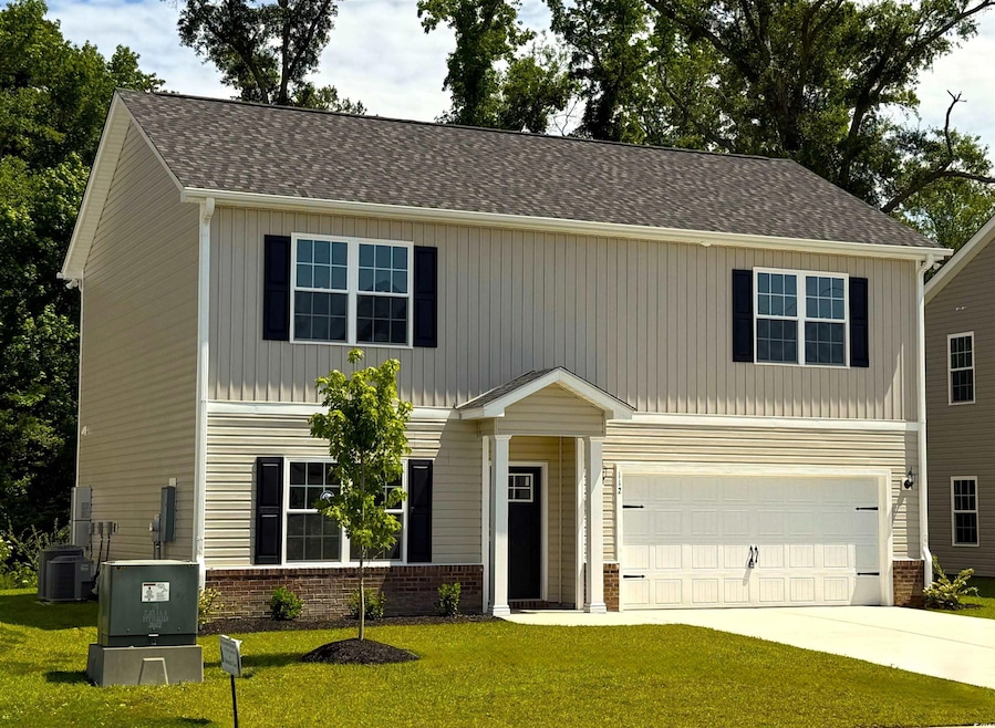 View of front facade with a garage, concrete driveway, central air condition unit, a front yard, and brick siding