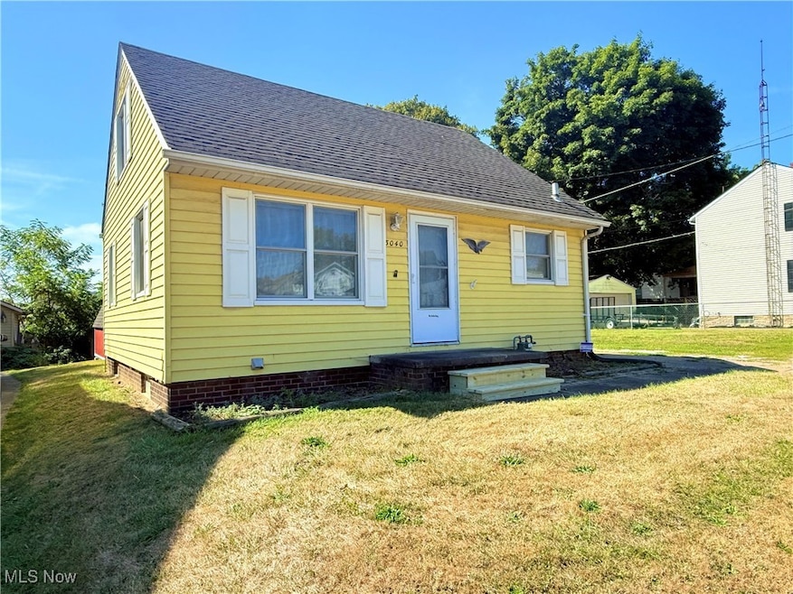 Bungalow-style house featuring roof with shingles and a front lawn