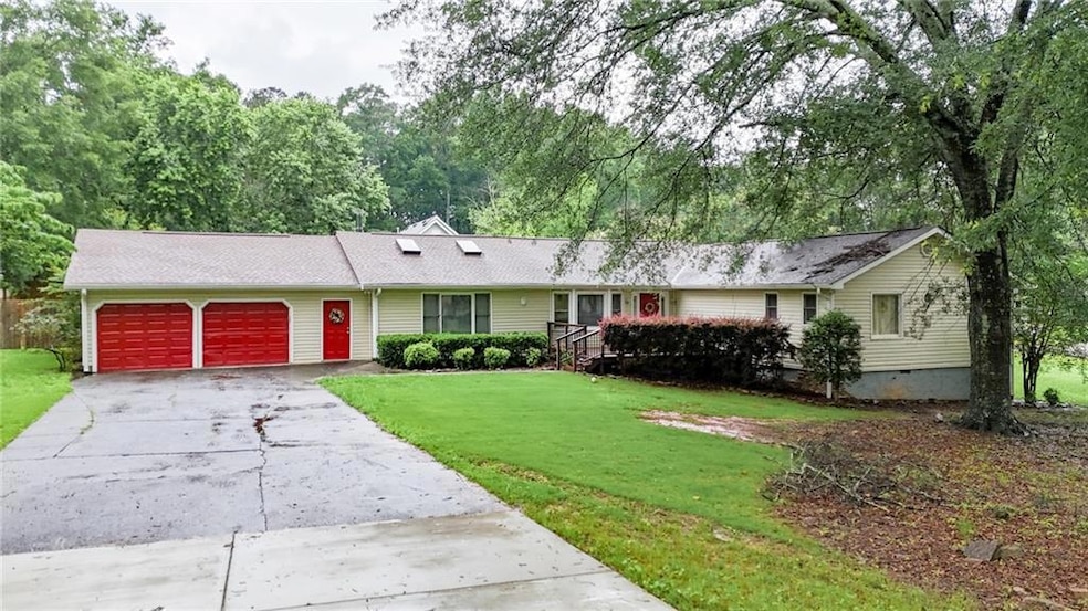 Ranch-style home featuring a garage, a front lawn, driveway, and crawl space