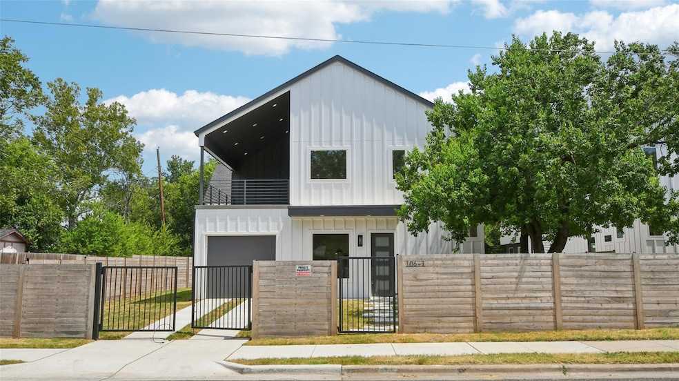 View of front of property featuring a gate, a fenced front yard, board and batten siding, a balcony, and driveway