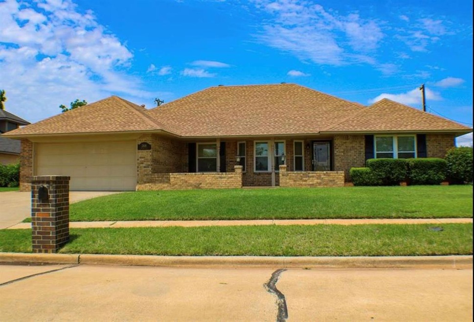 Ranch-style home featuring a garage and a front ya