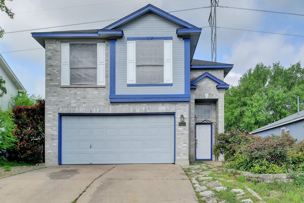 View of front of property featuring an attached garage, brick siding, and driveway
