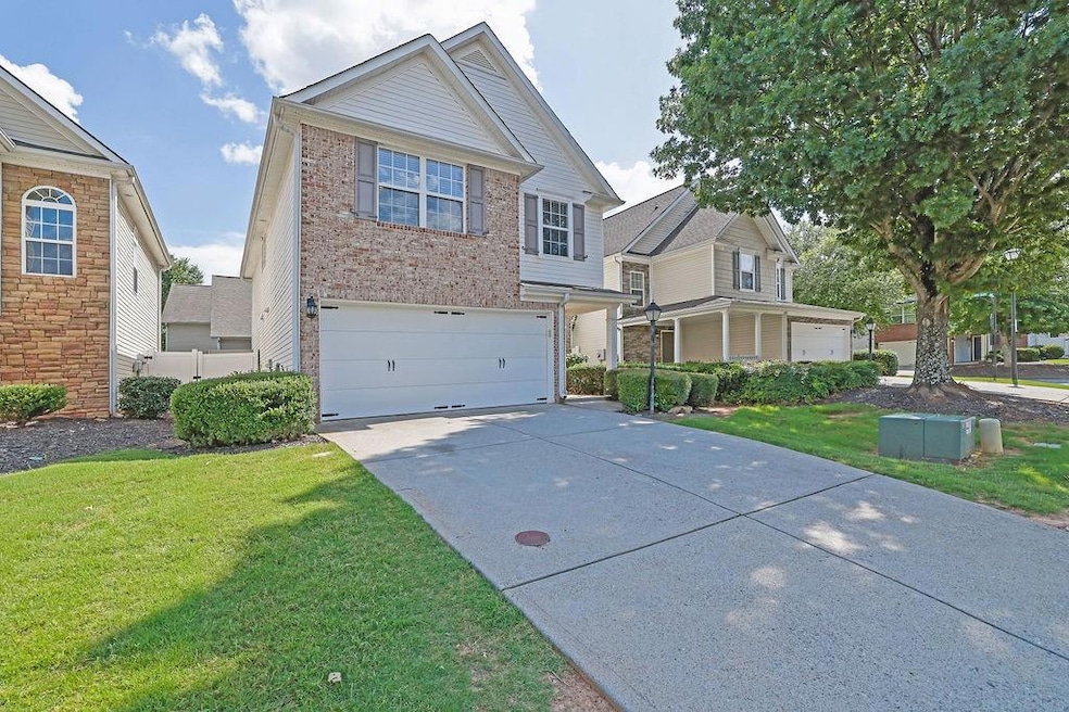 View of front of house with brick siding, concrete driveway, an attached garage, and a front yard