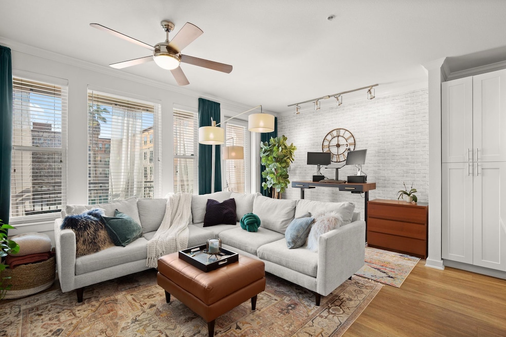 Living room featuring a ceiling fan, light wood-s