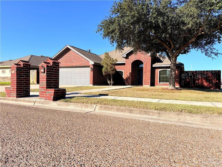 Ranch-style home with brick siding, an attached garage, and driveway