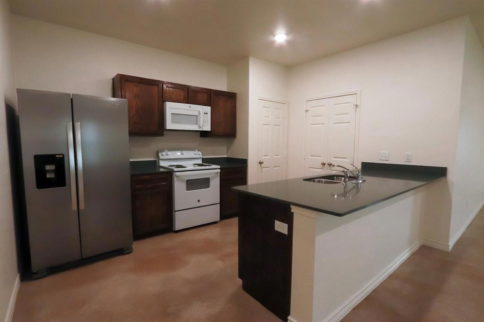 Kitchen featuring dark brown cabinetry, a sink, d