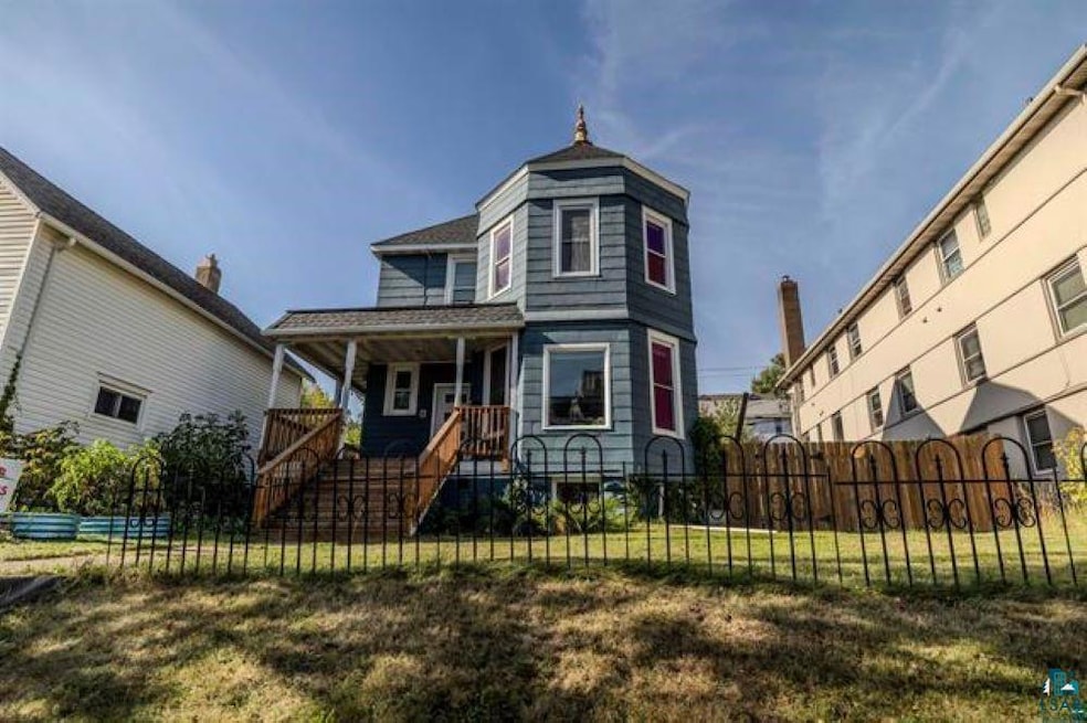 Victorian-style house with covered porch and a fen