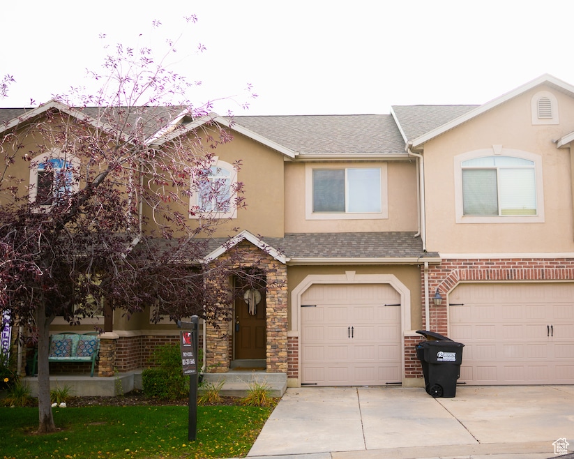 Traditional home featuring concrete driveway, stucco siding, and a garage