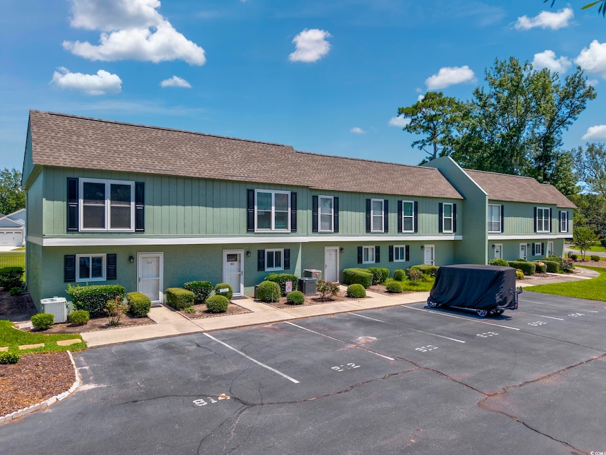 View of front of property featuring roof with shingles, uncovered parking, and a residential view