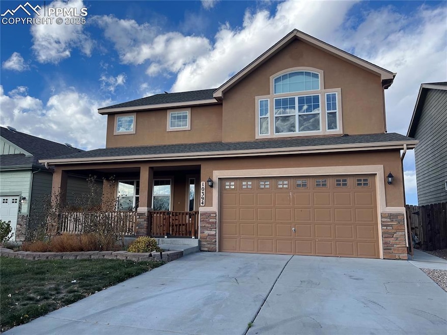 Craftsman-style house featuring stone siding, a porch, stucco siding, and an attached garage