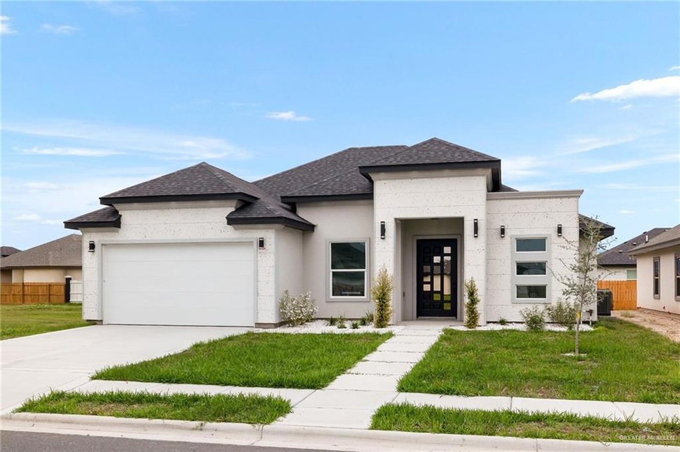 View of front of home featuring a garage, a front yard, and central AC