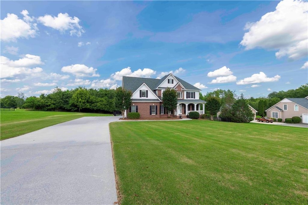 View of front of home with a front yard, driveway, and covered porch
