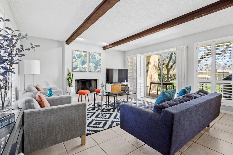 Living area with a textured ceiling, beamed ceili