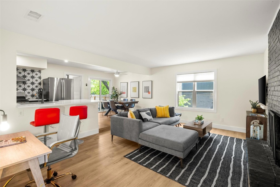 Living room featuring a brick fireplace, baseboar