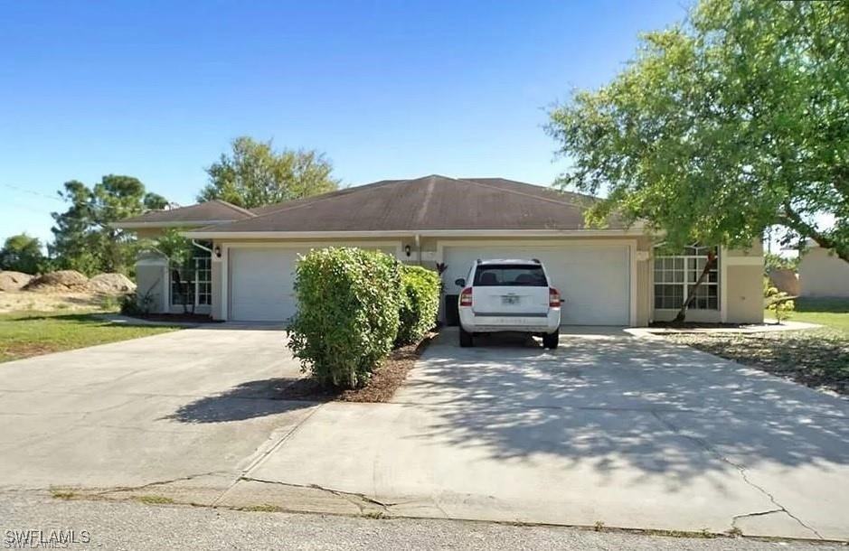 View of front of house with driveway and an attach